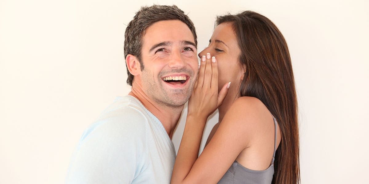 Photo of a happy couple, woman is whisphering to his man