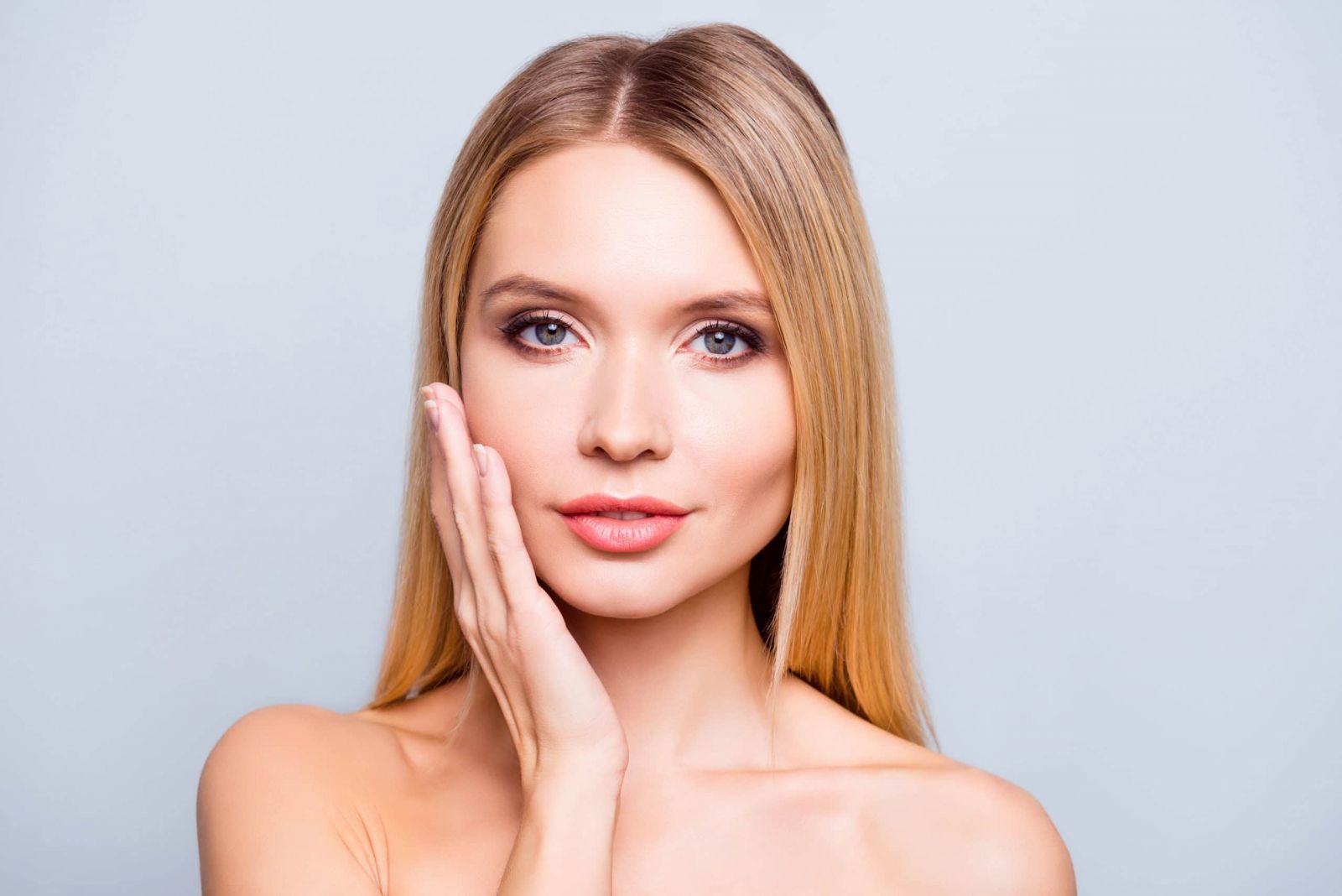 Young woman with hand on her left cheek