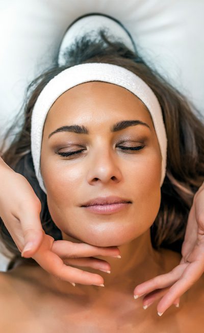 Female patient with eyes closed undergoing skin tightening treatment to her face