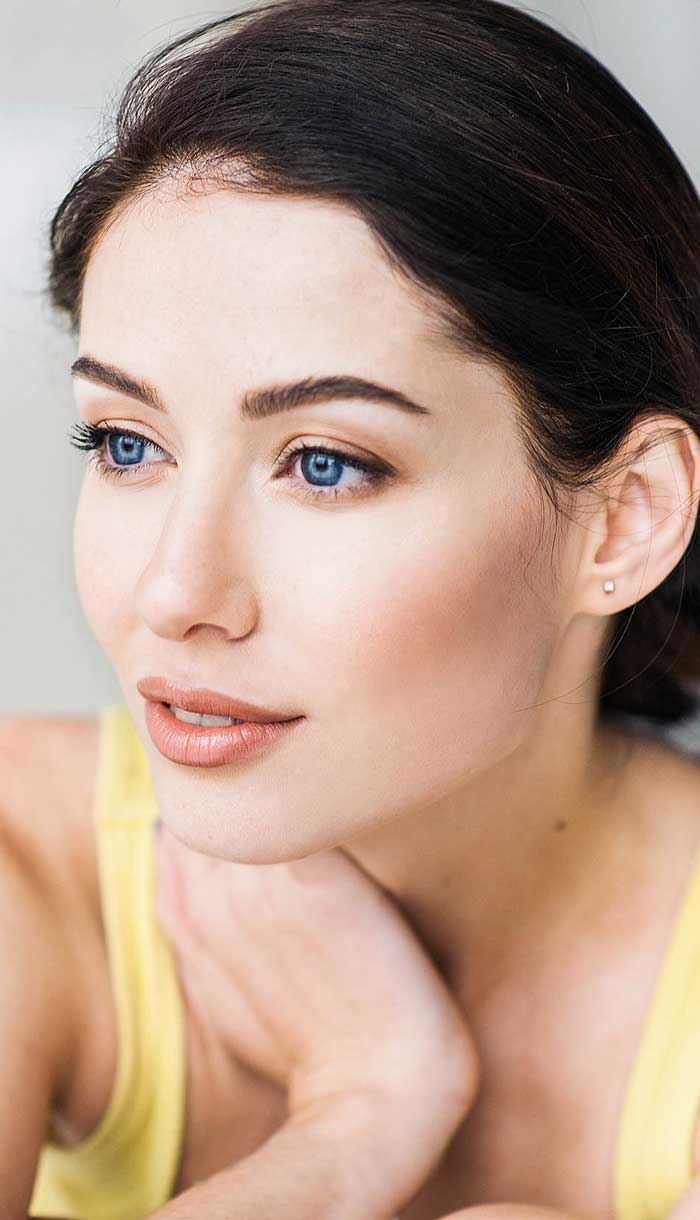 Young woman receiving local laser skin tightening on her face